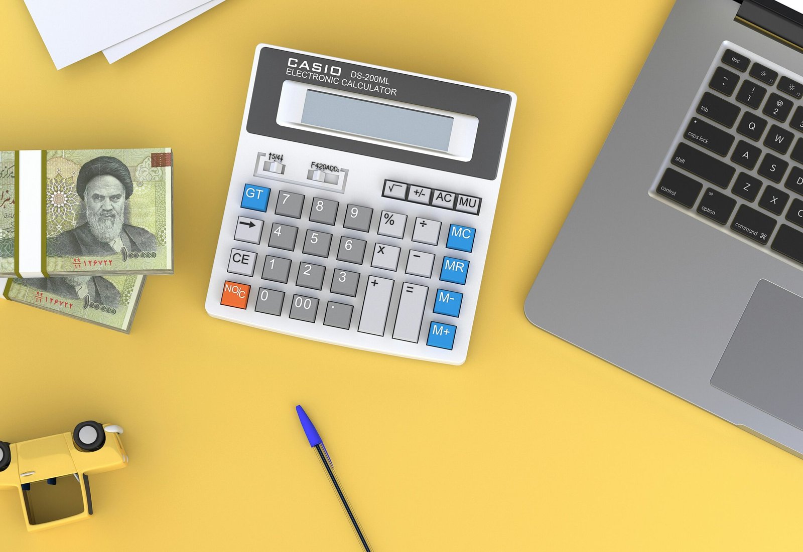 a calculator sitting on a calculator sitting on top of a desk next to a laptop